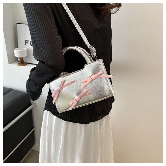 Túi xách cầm tay nơ màu bột sáng màu bạc